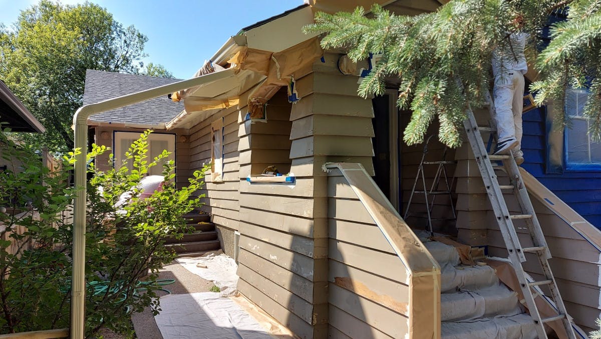 exterior siding of a house in Calgary being prepared for exterior painting - the actual colour is light brown